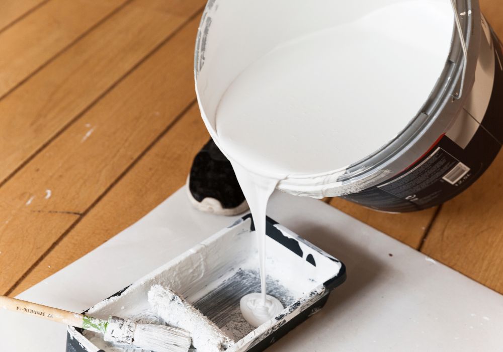 An image of a wall primer being poured onto a pallet.