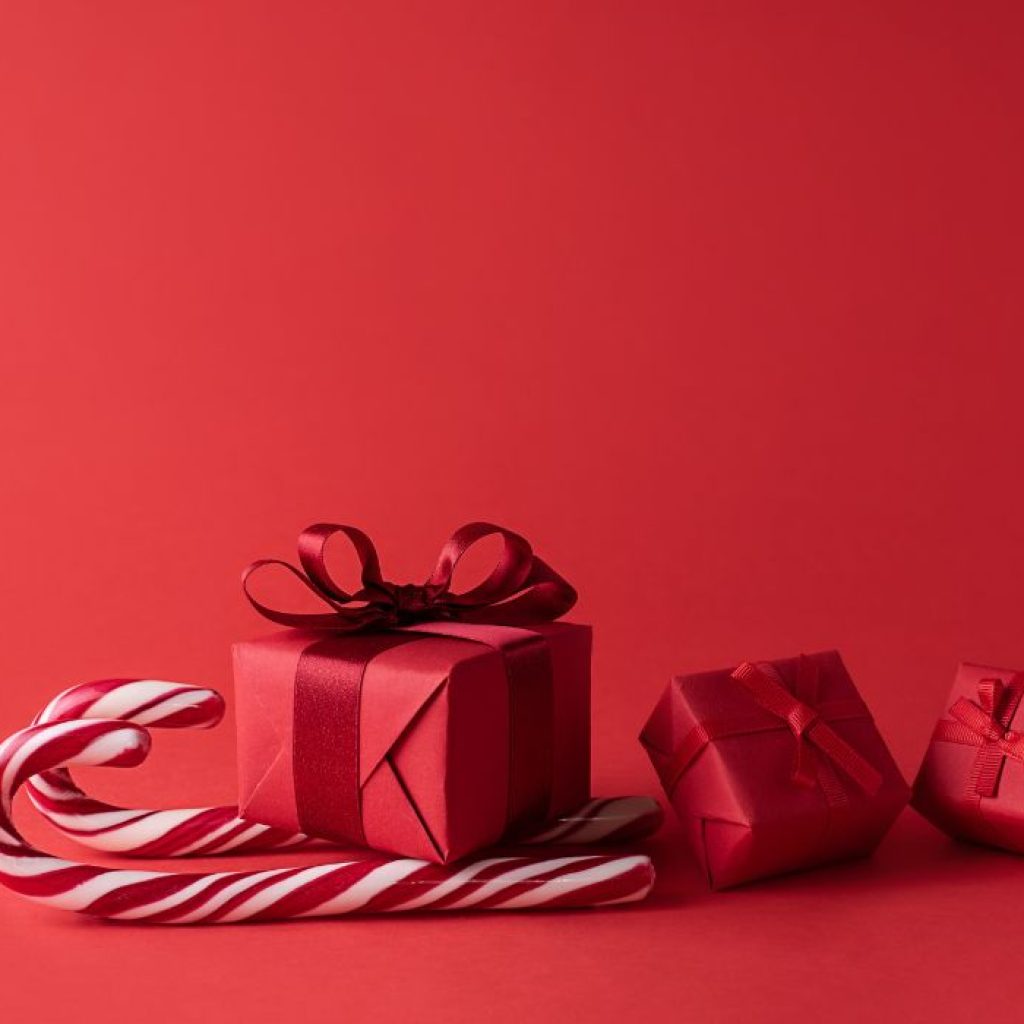 An image of a red gift box on top of two candy canes. 